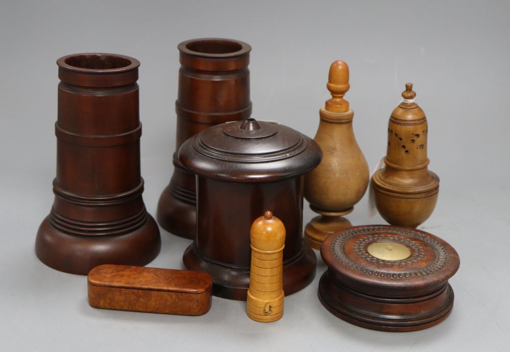 Eight items of treen including a pair of spill vases, height 16cm, a string box and a caster,